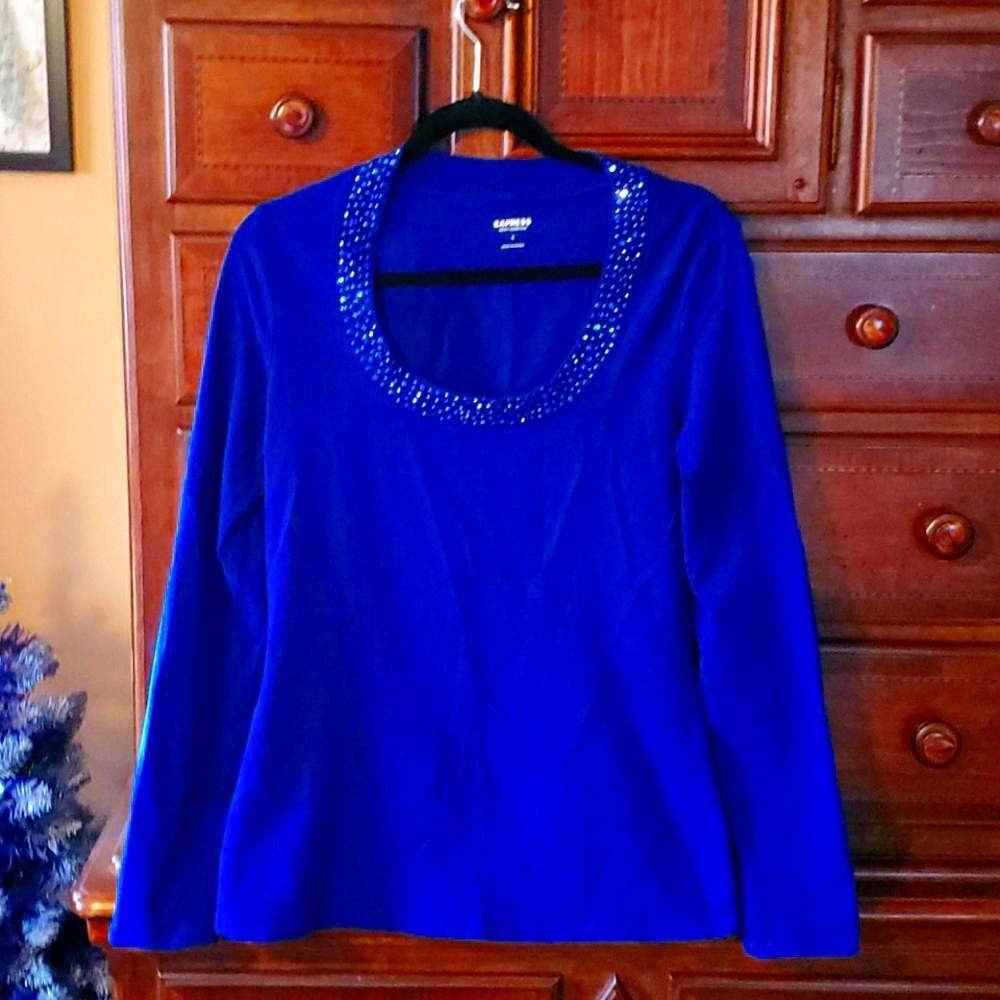 Express long sleeve with embellished neckline.
